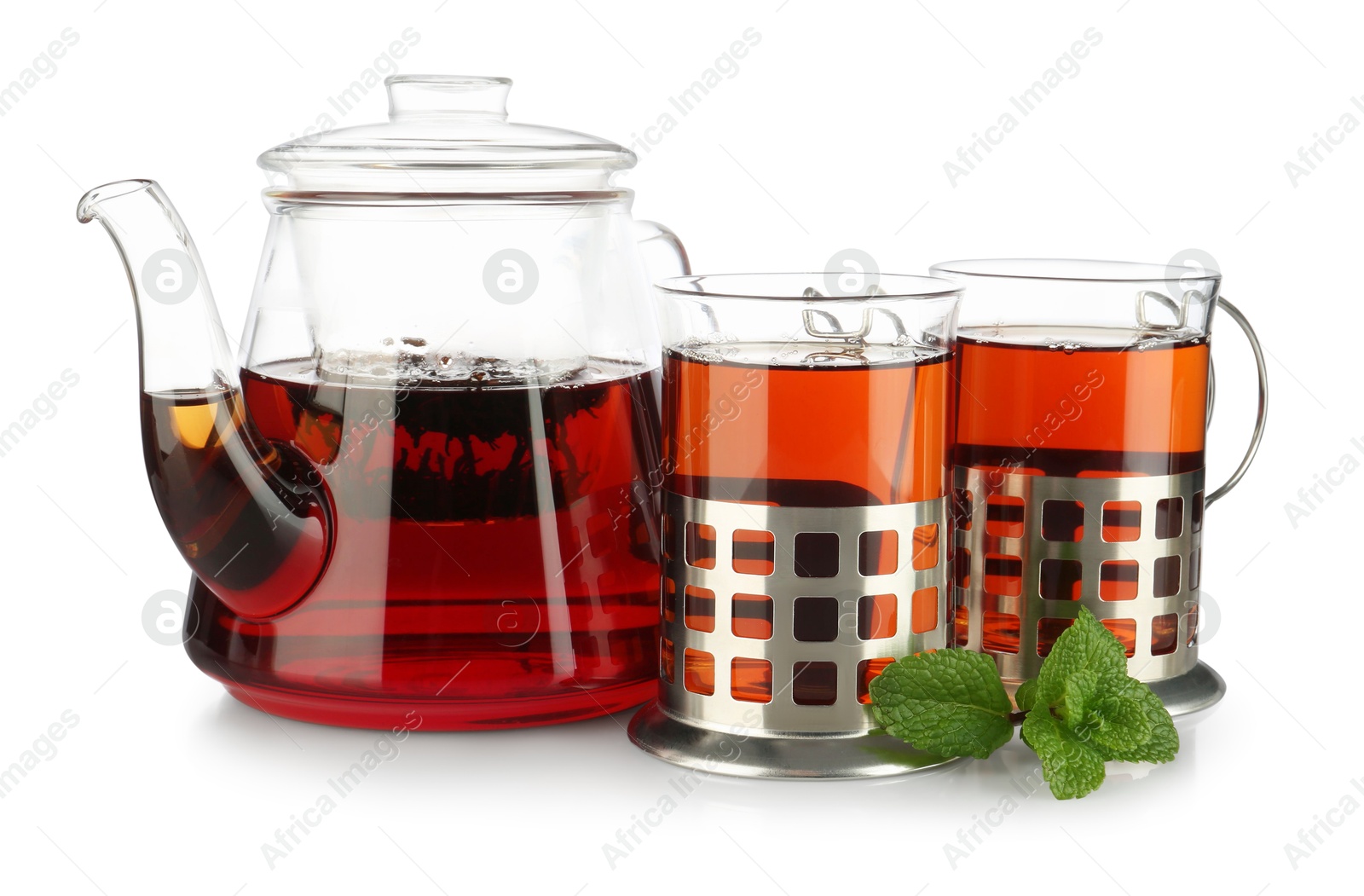 Photo of Glasses of aromatic tea in holders, teapot and mint isolated on white