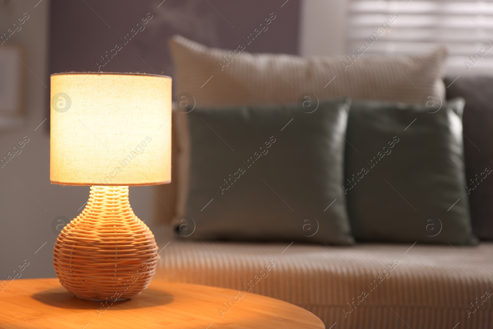 Photo of Stylish night lamp on wooden table in room, space for text