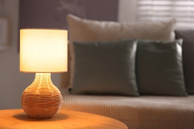 Photo of Stylish night lamp on wooden table in room, space for text