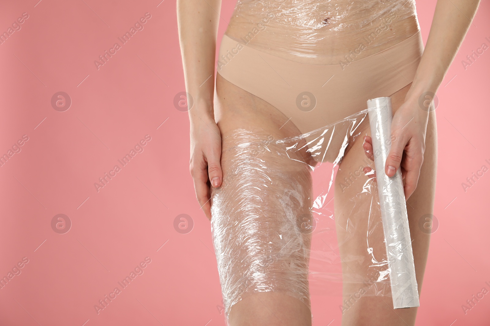 Photo of Woman doing spa body wraps on pink background, closeup