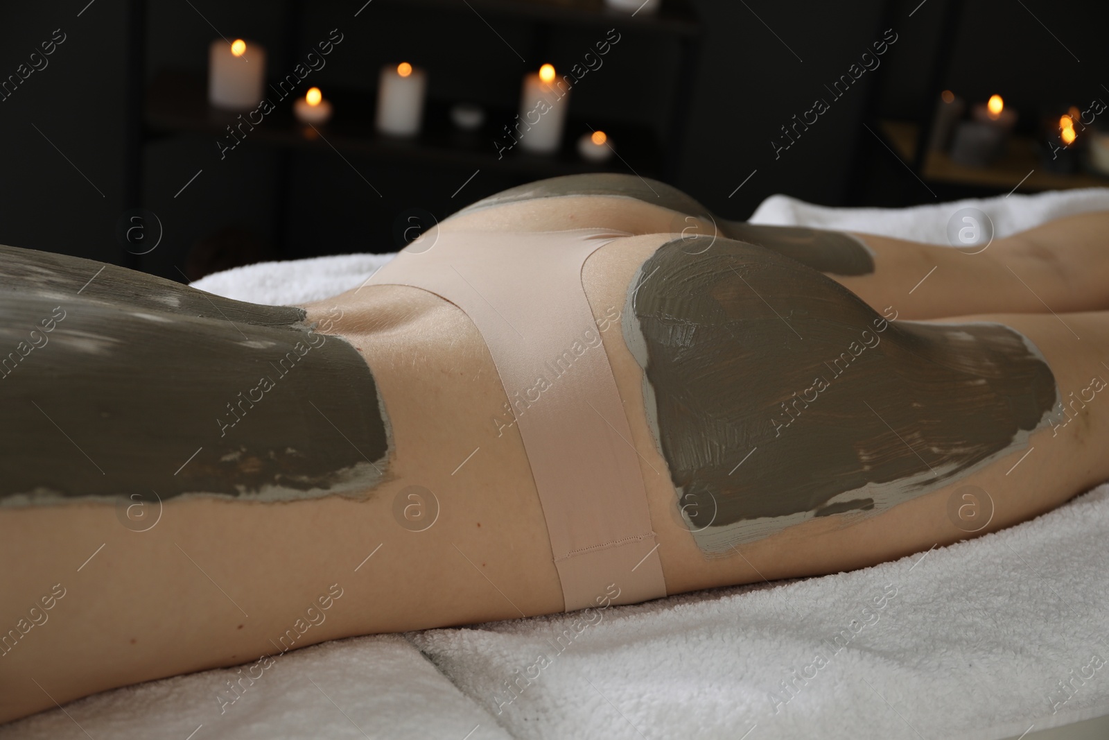 Photo of Woman undergoing body wraps treatment in spa salon, closeup