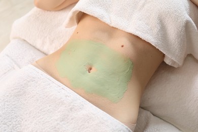 Photo of Woman undergoing body wraps treatment in spa salon, above view