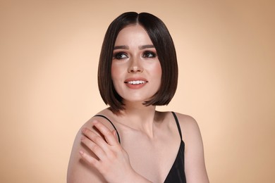 Portrait of beautiful young happy woman with gorgeous straight hair on beige background