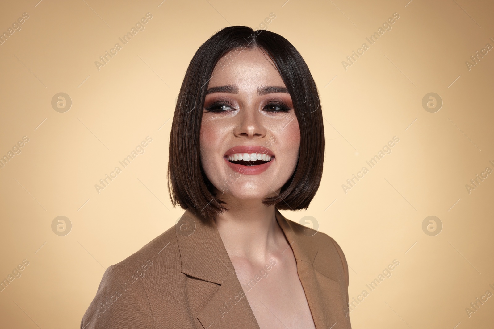 Photo of Portrait of beautiful young happy woman with gorgeous straight hair on beige background