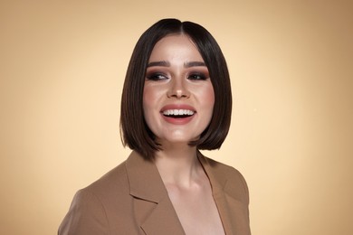 Portrait of beautiful young happy woman with gorgeous straight hair on beige background