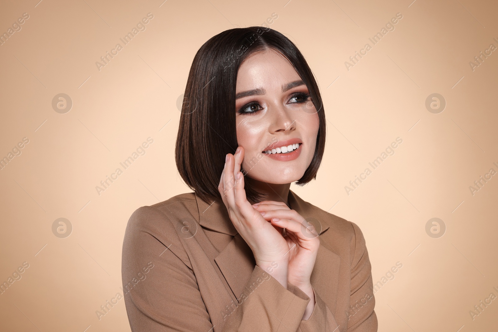 Photo of Portrait of beautiful young happy woman with gorgeous straight hair on beige background