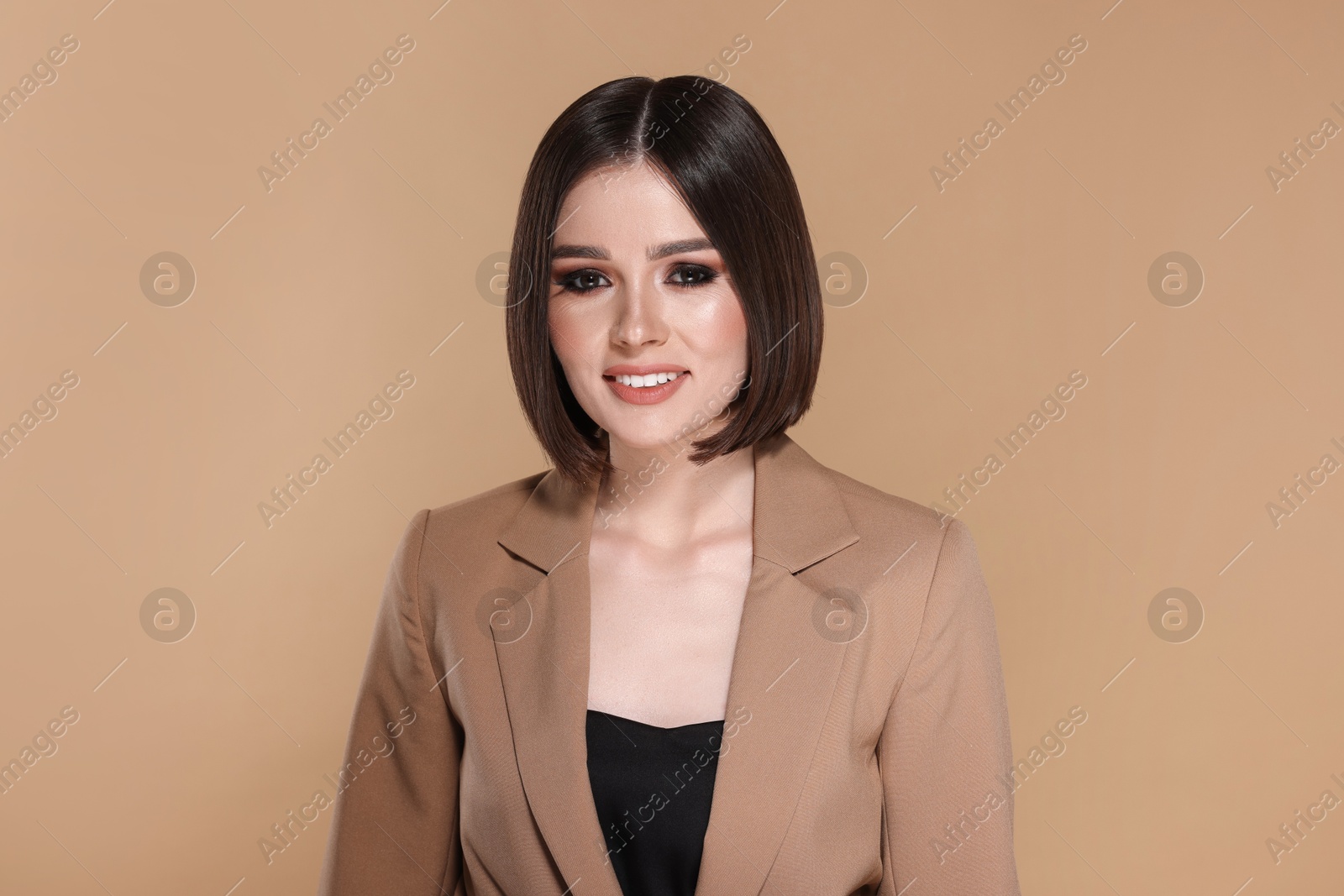 Photo of Portrait of beautiful young happy woman with gorgeous straight hair on beige background