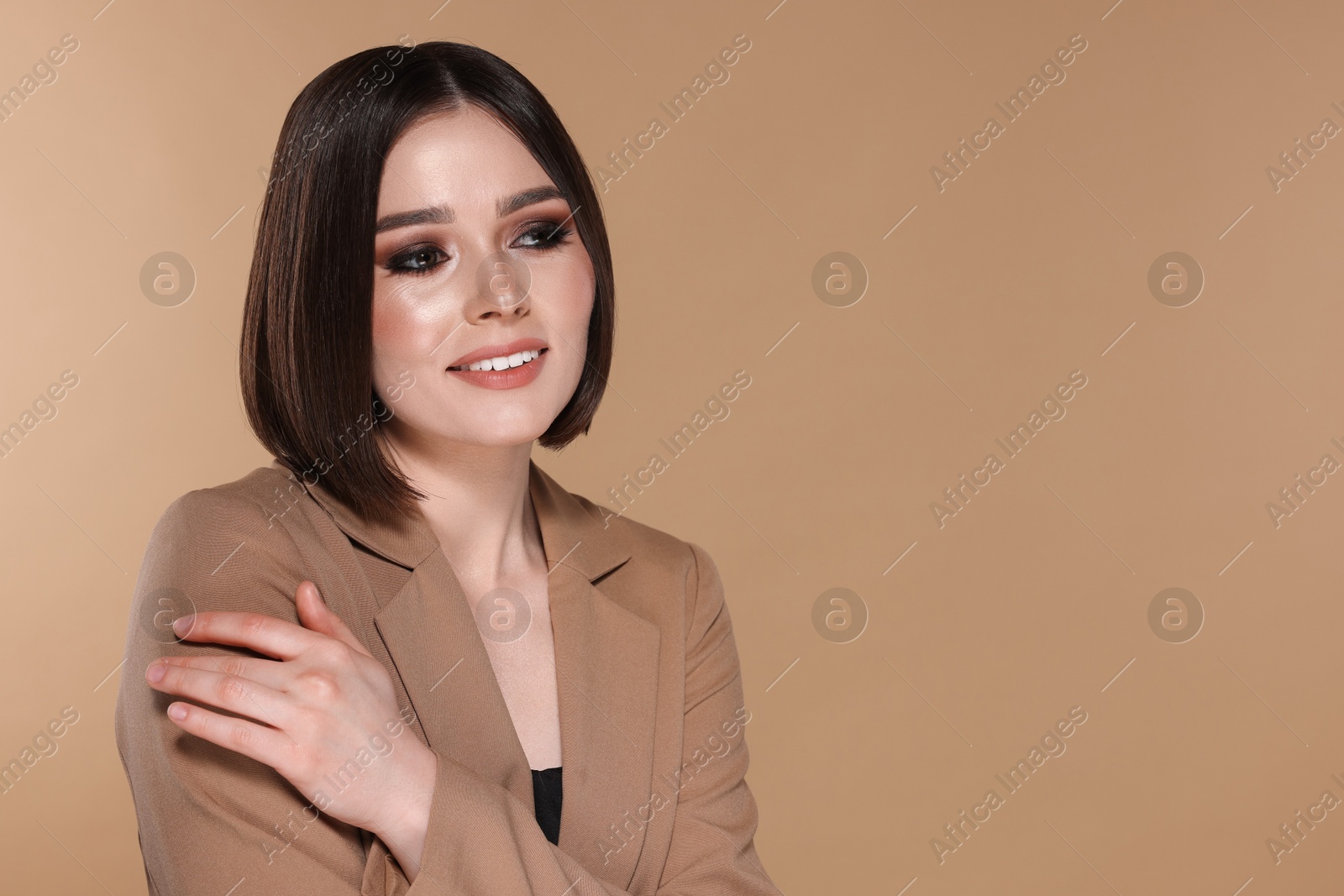 Photo of Portrait of beautiful young happy woman with gorgeous straight hair on beige background, space for text