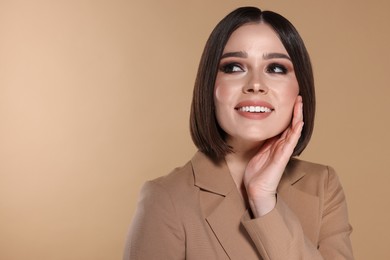 Portrait of beautiful young happy woman with gorgeous straight hair on beige background, space for text