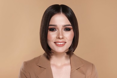 Photo of Portrait of beautiful young happy woman with gorgeous straight hair on beige background