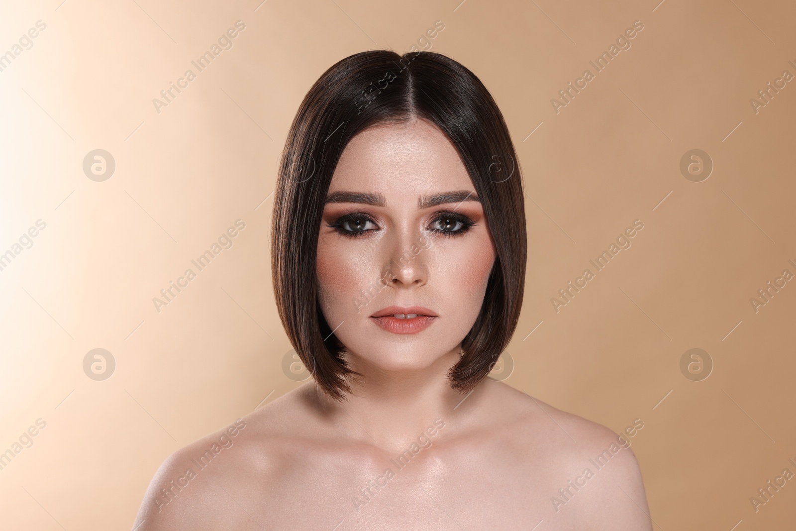 Photo of Portrait of beautiful young woman with gorgeous straight hair on beige background