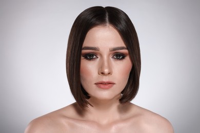 Photo of Portrait of beautiful young woman with gorgeous straight hair on light grey background