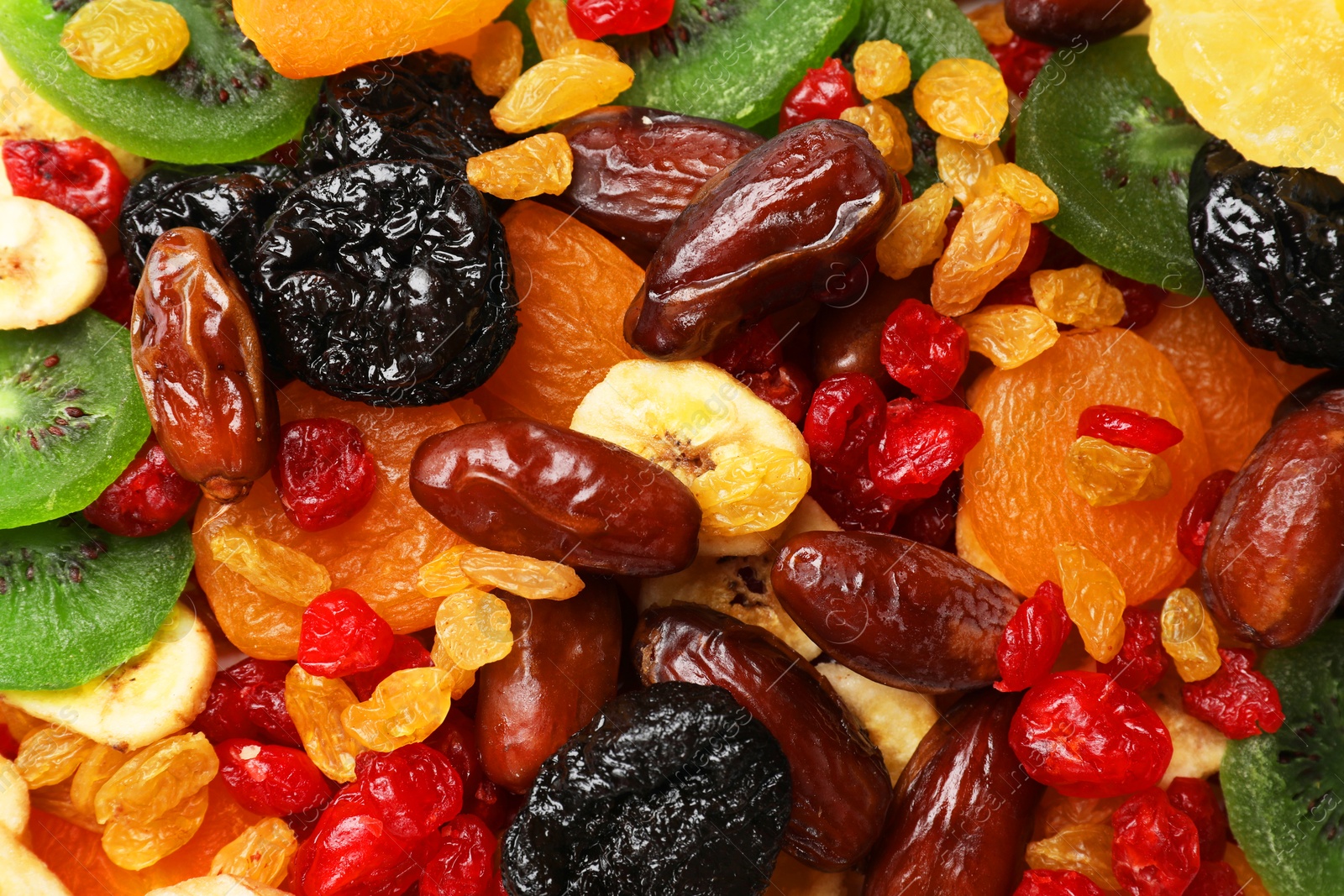 Photo of Mix of different dried fruits as background, closeup