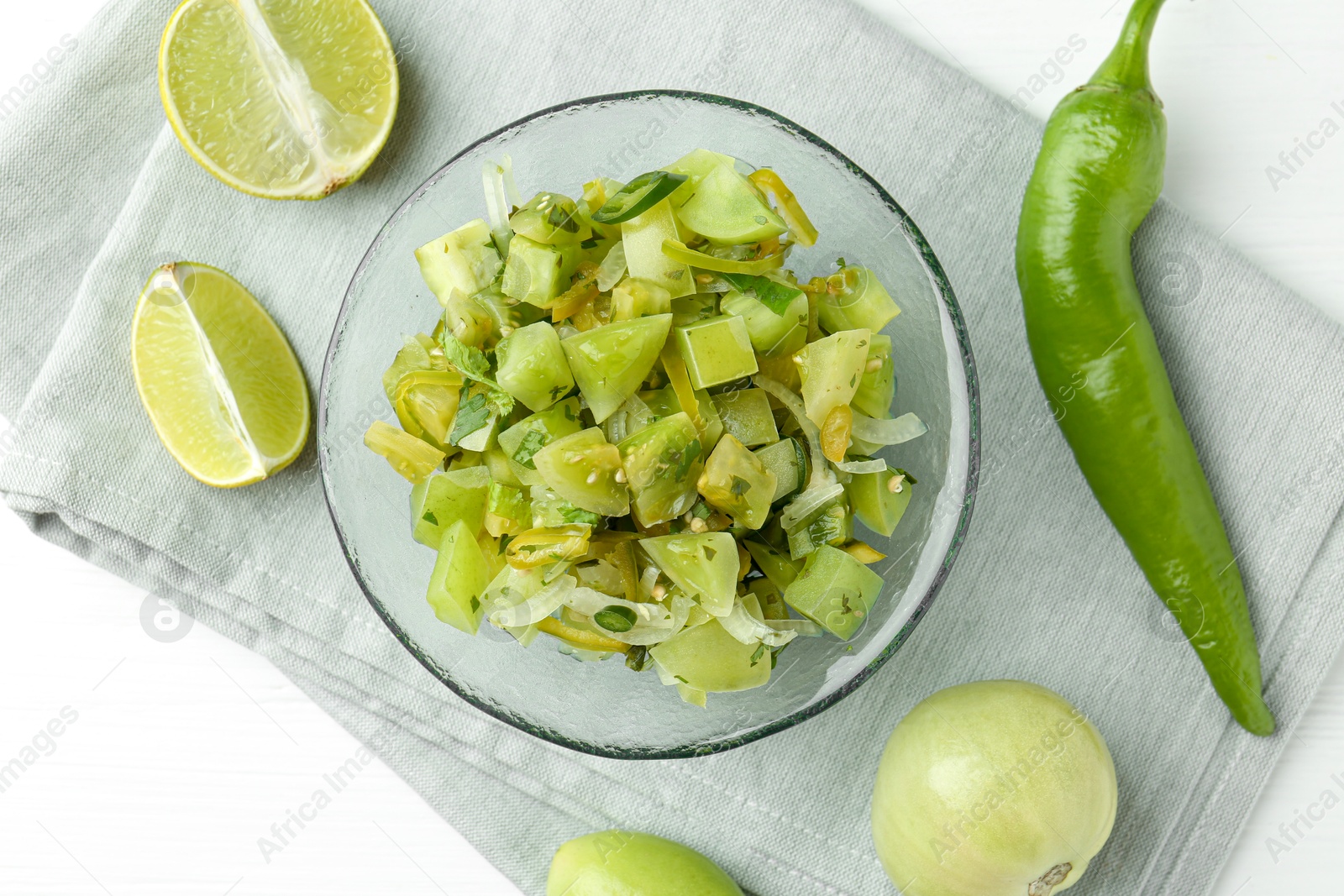 Photo of Delicious salsa (Pico de gallo) in bowl and products on white table, top view