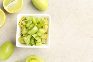 Photo of Delicious salsa (Pico de gallo) in bowl and products on light textured table, flat lay. Space for text