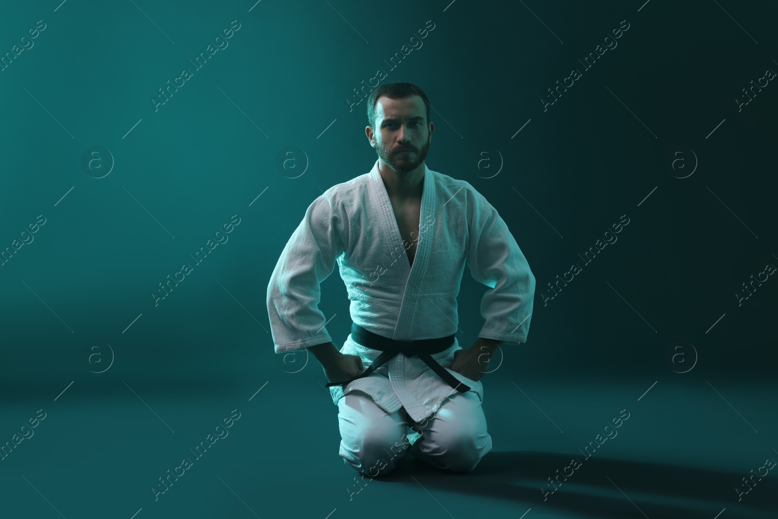 Photo of Karate fighter wearing uniform in color lights