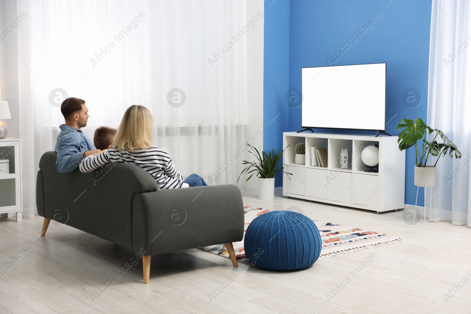 Photo of Happy family watching tv together at home