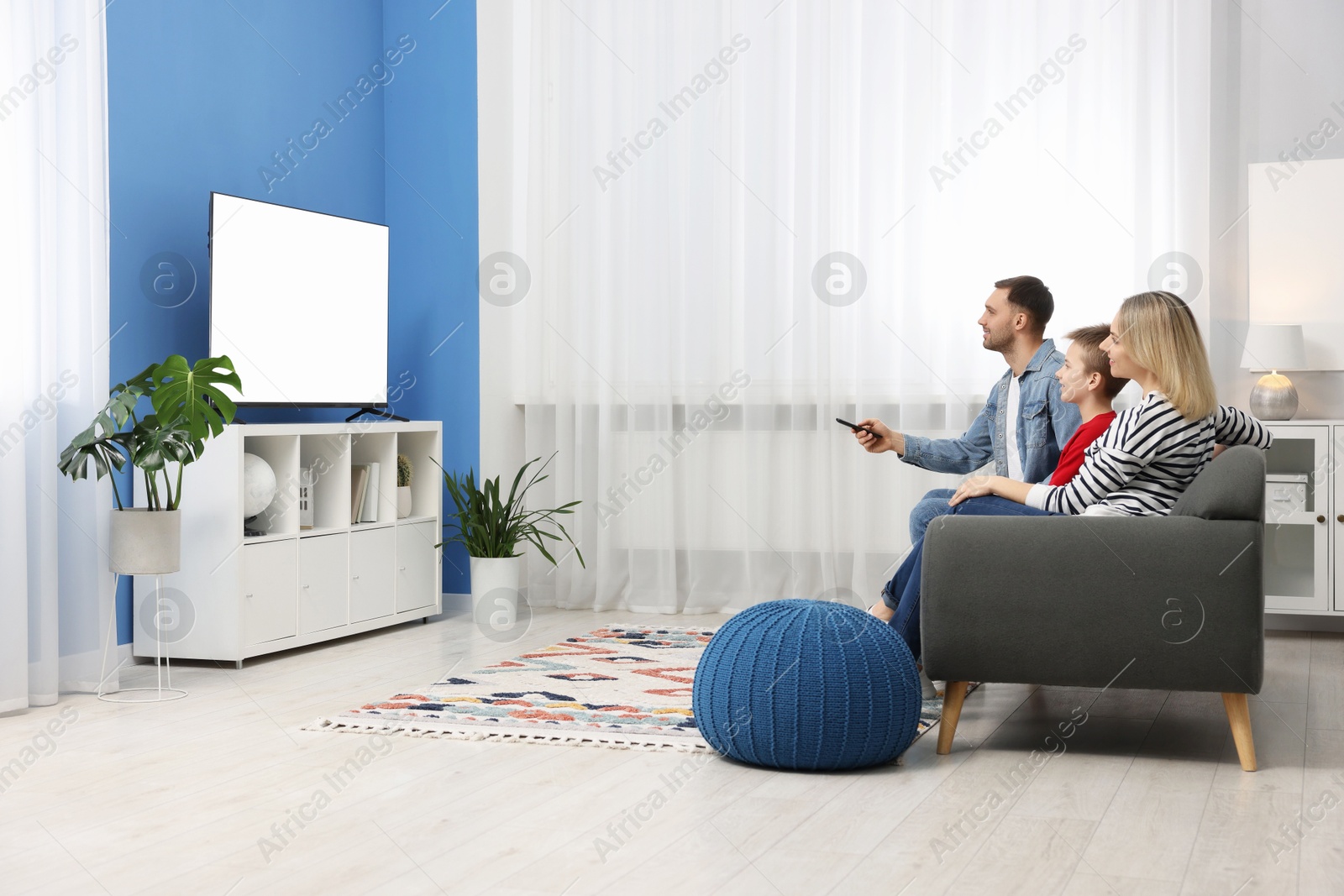 Photo of Happy family watching tv together at home