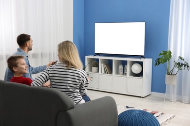 Happy family watching tv together at home