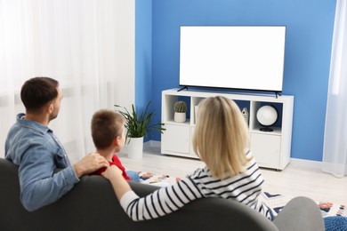 Happy family watching tv together at home