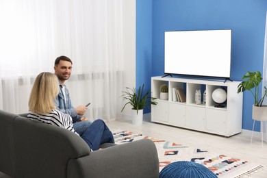 Lovely couple watching tv on couch at home