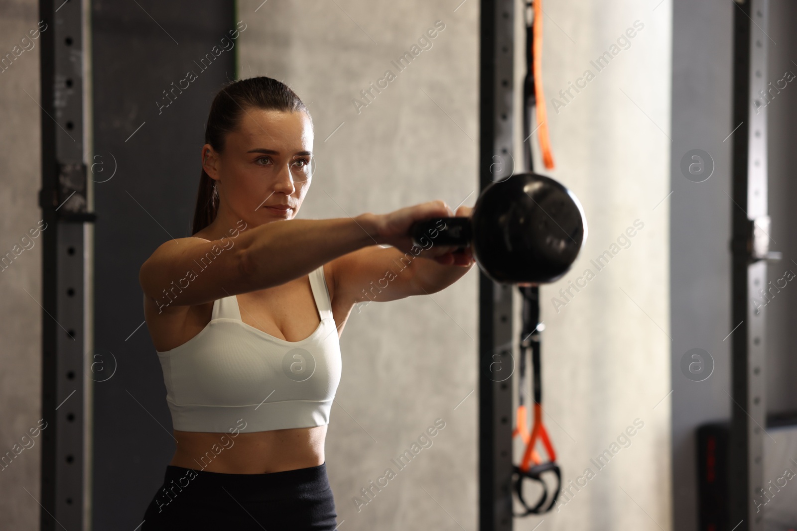 Photo of Sportswoman doing kettlebell swing during crossfit workout in gym