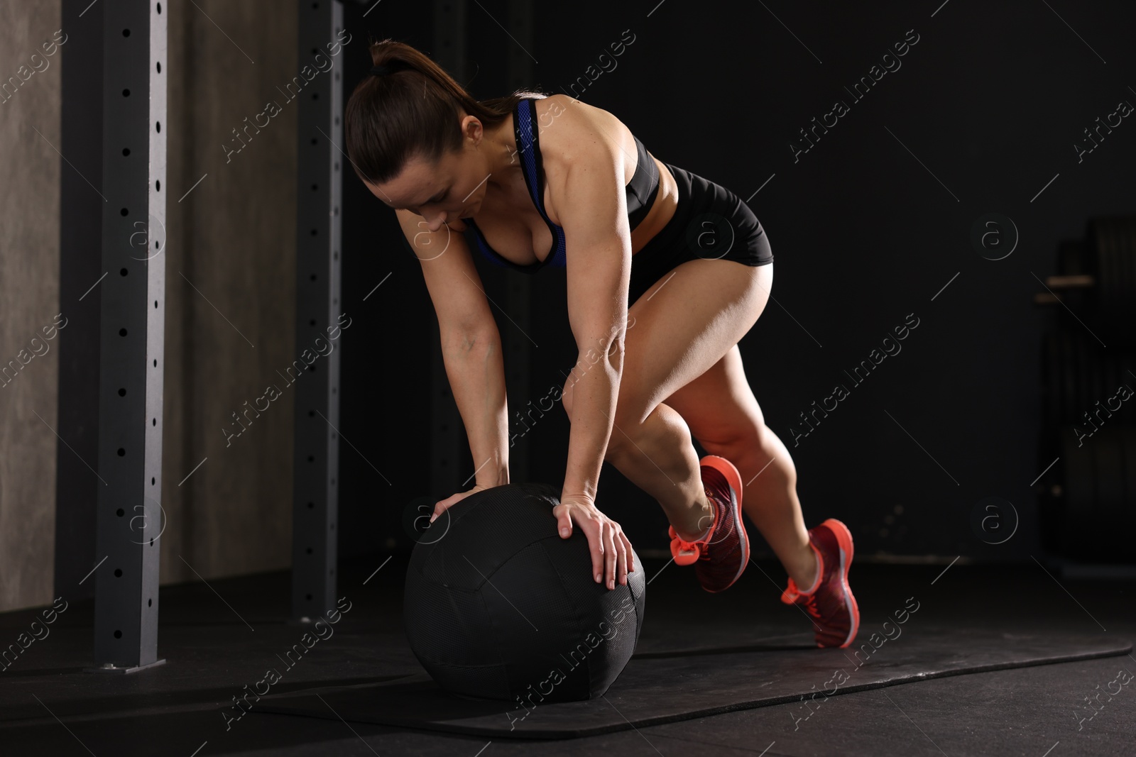 Photo of Sportswoman exercising with wall ball during crossfit workout in gym