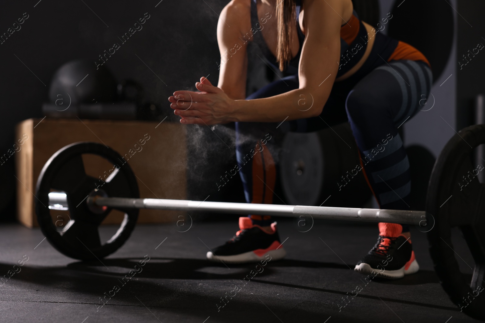 Photo of Sportswoman with barbell during crossfit workout in gym, closeup