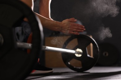 Photo of Sportswoman with barbell during crossfit workout in gym, closeup