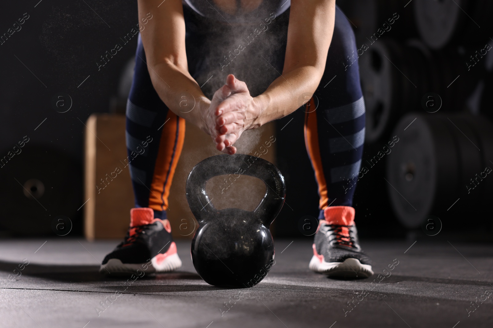 Photo of Sportswoman with kettlebell during crossfit workout in gym, closeup