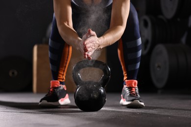 Photo of Sportswoman with kettlebell during crossfit workout in gym, closeup