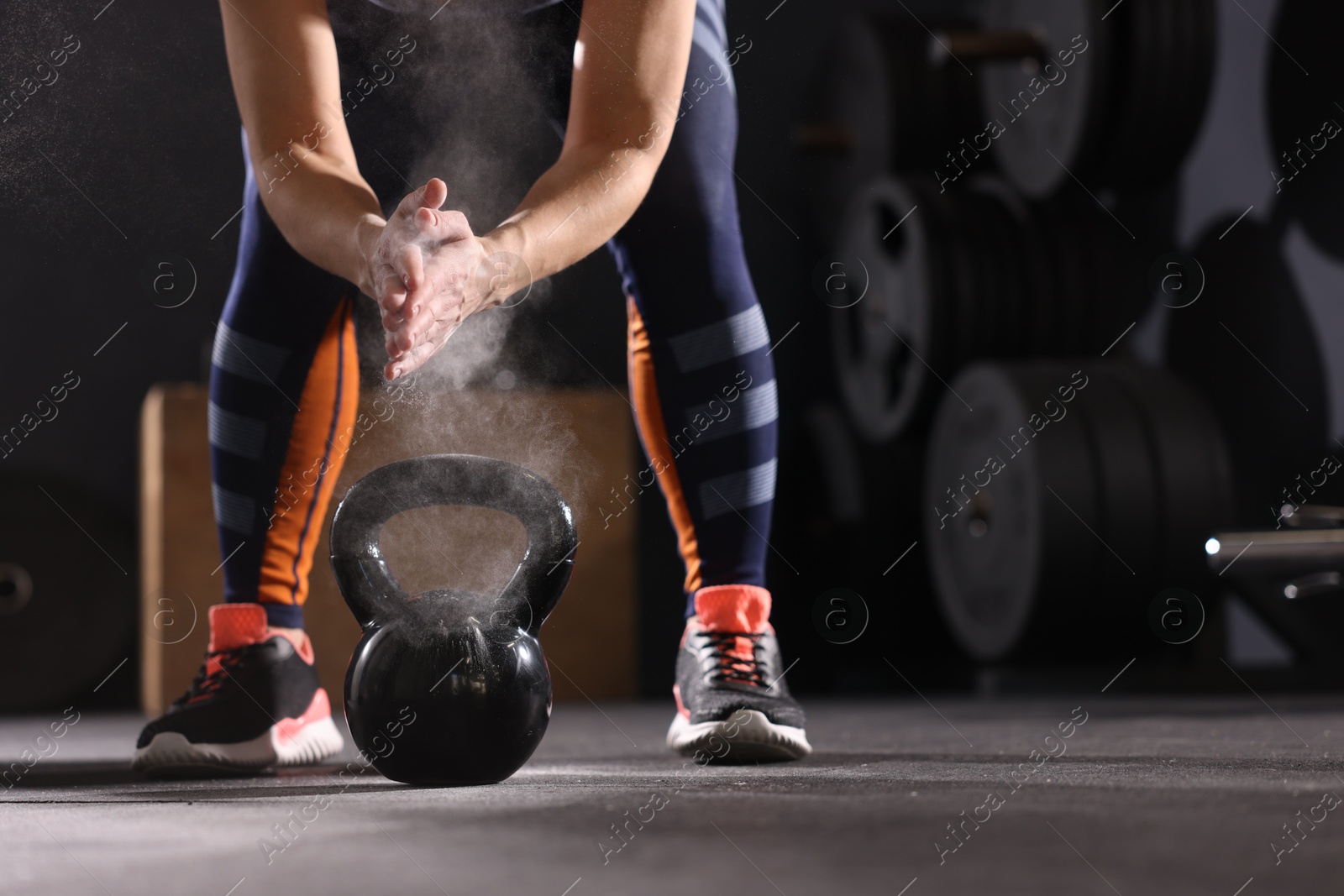 Photo of Sportswoman with kettlebell during crossfit workout in gym, closeup