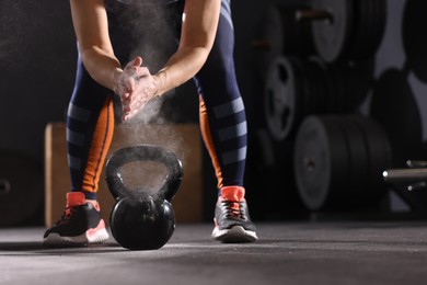 Photo of Sportswoman with kettlebell during crossfit workout in gym, closeup