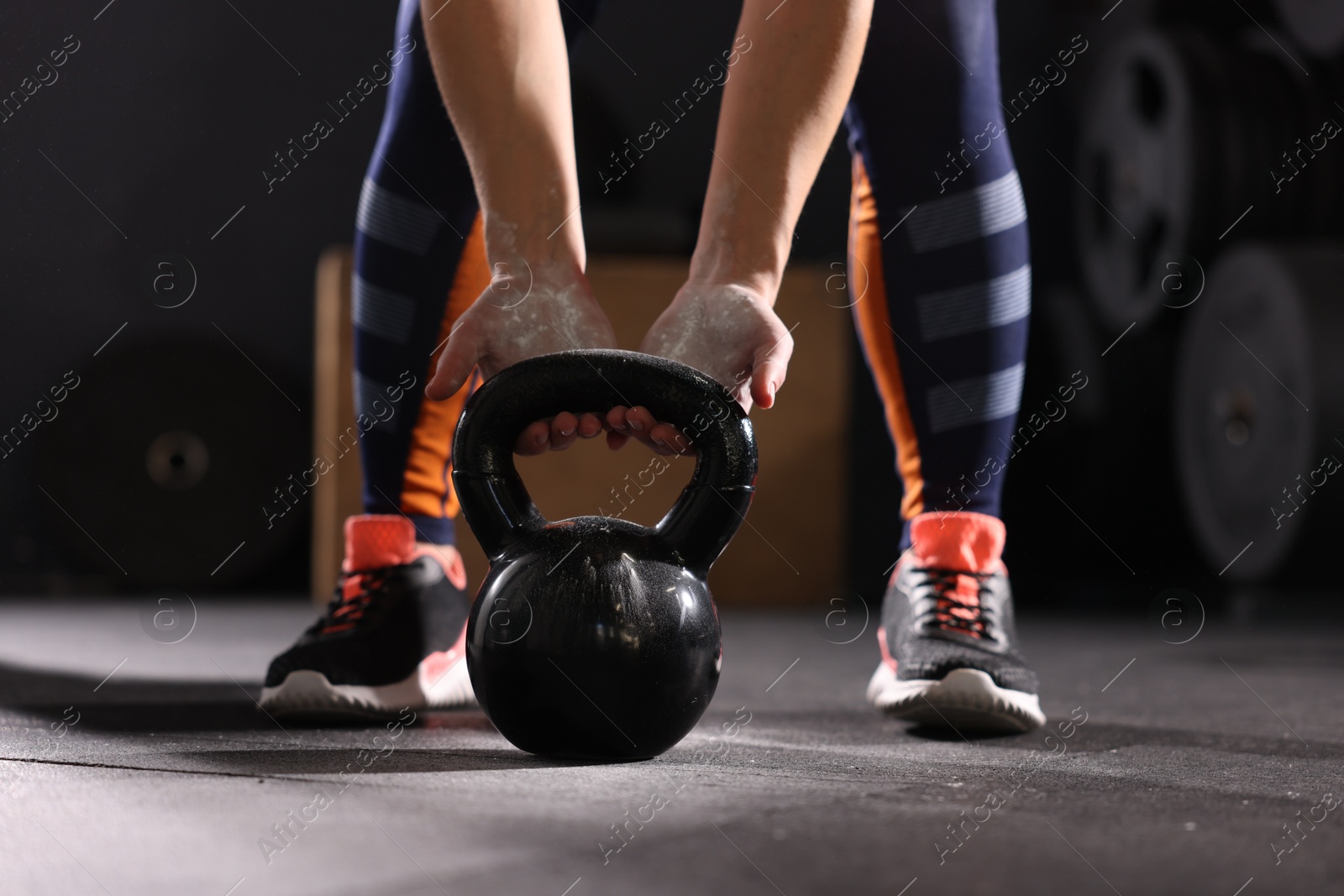 Photo of Sportswoman with kettlebell during crossfit workout in gym, closeup