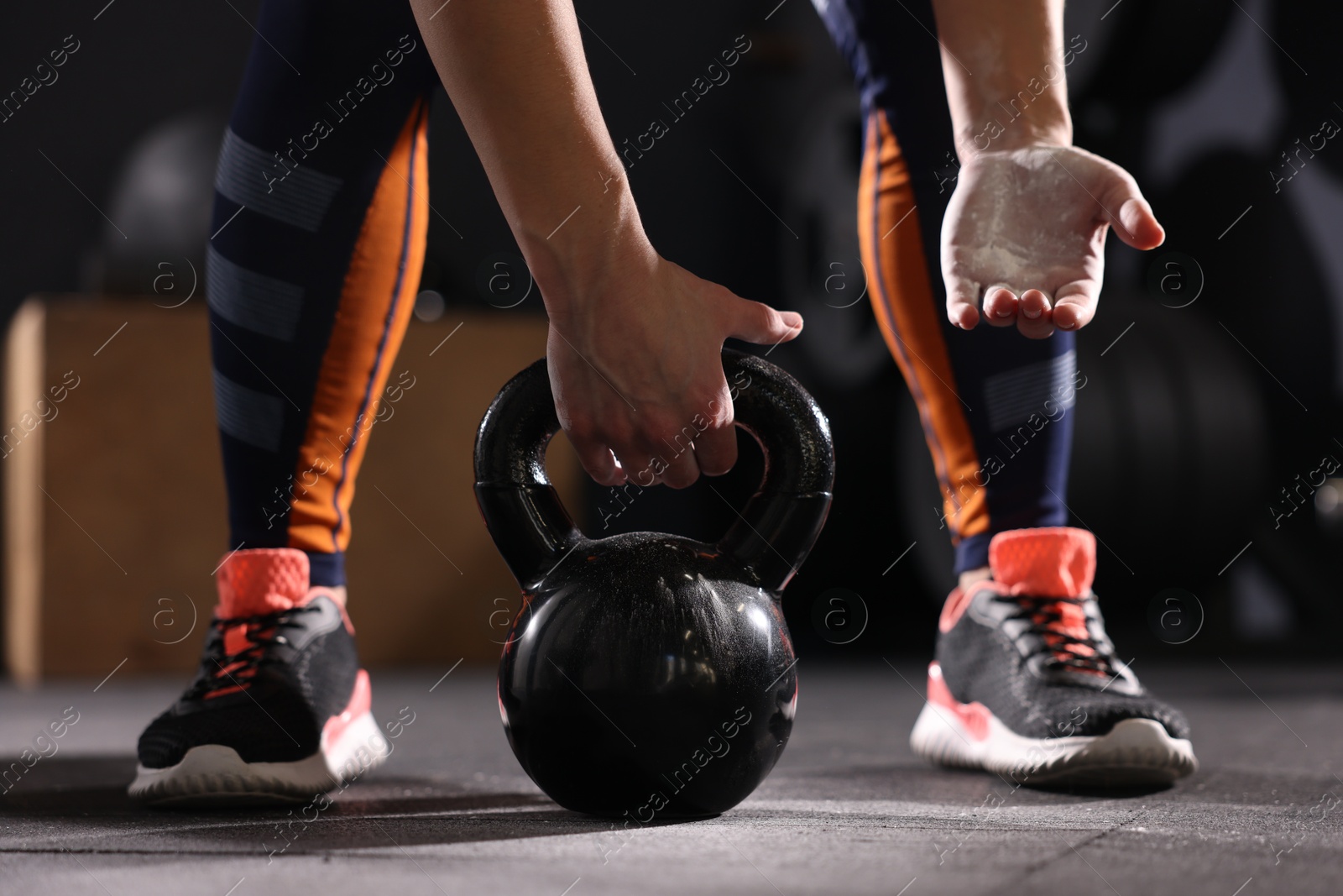 Photo of Sportswoman with kettlebell during crossfit workout in gym, closeup