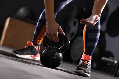 Photo of Sportswoman with kettlebell during crossfit workout in gym, closeup