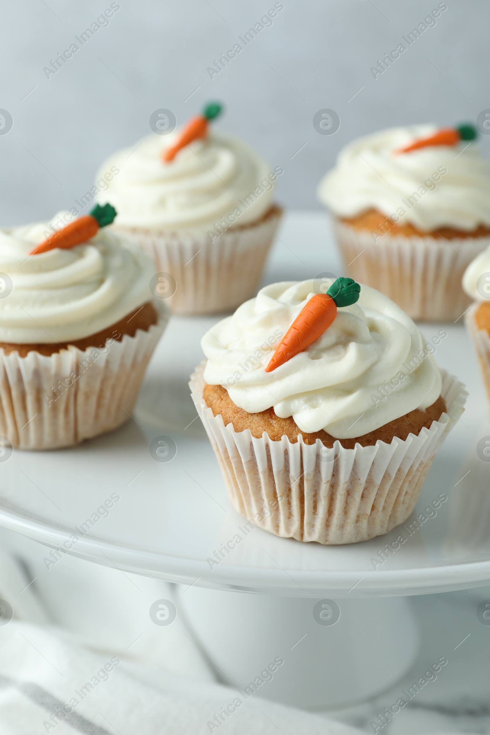 Photo of Delicious carrot cupcakes on table against grey background, closeup