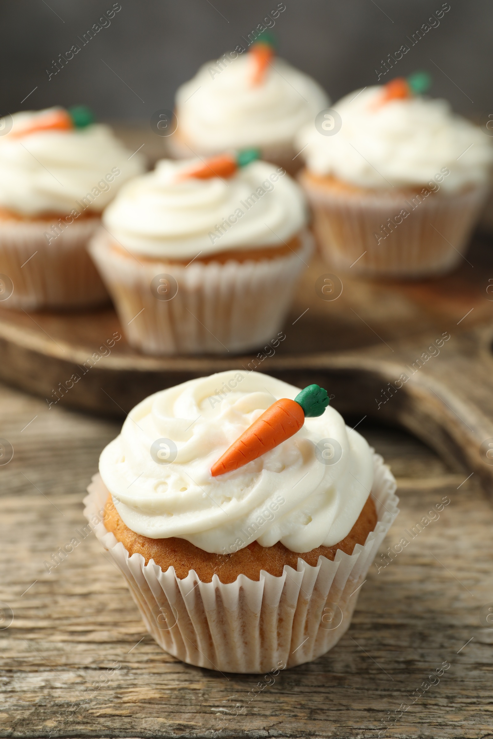 Photo of Delicious carrot cupcakes on wooden table, closeup