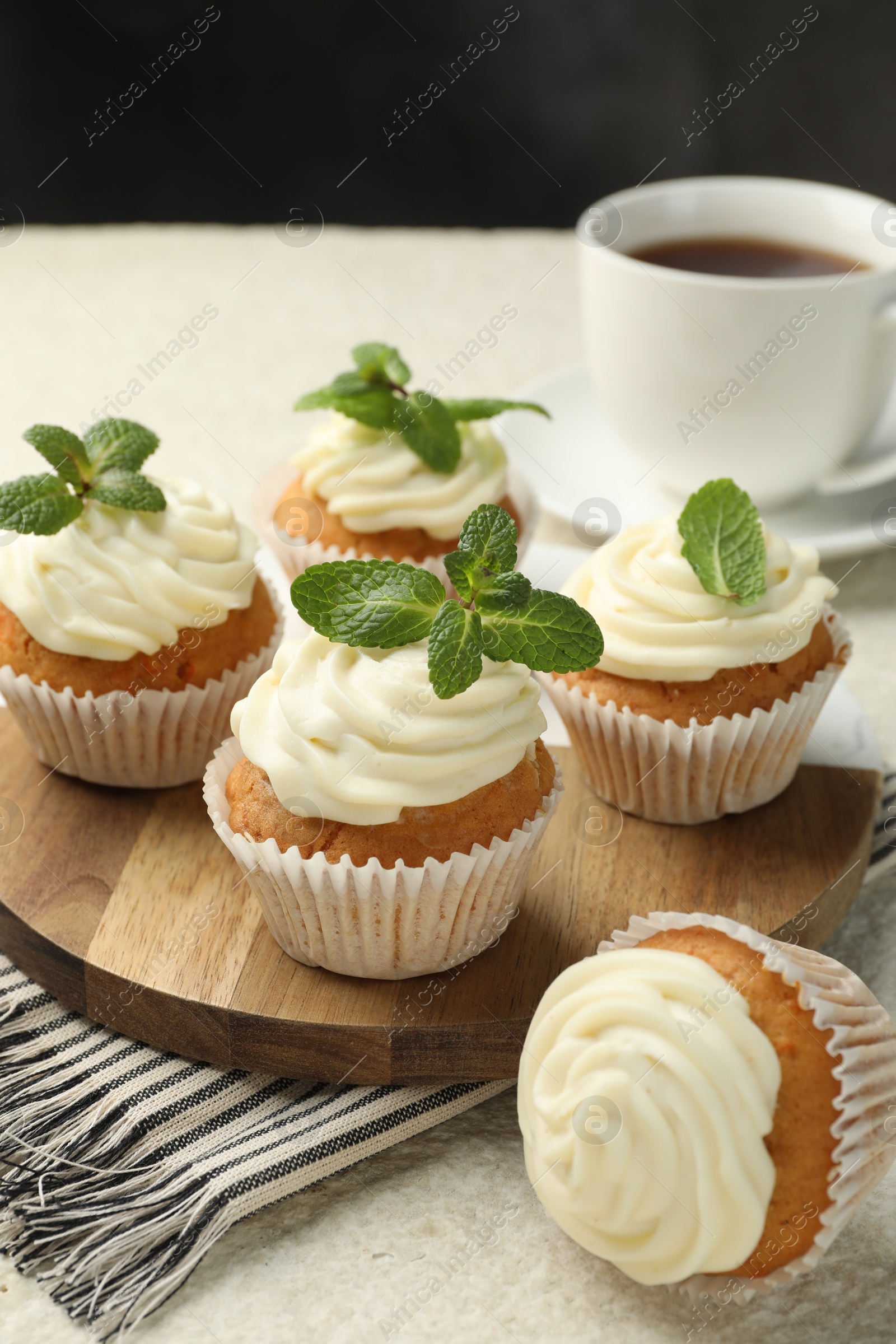 Photo of Delicious carrot cupcakes with mint and coffee on light textured table, closeup