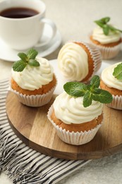 Photo of Delicious carrot cupcakes with mint and coffee on light textured table, closeup