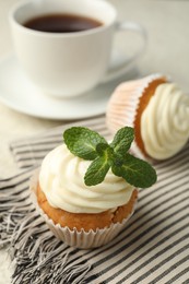 Photo of Delicious carrot cupcake with mint on light table, closeup