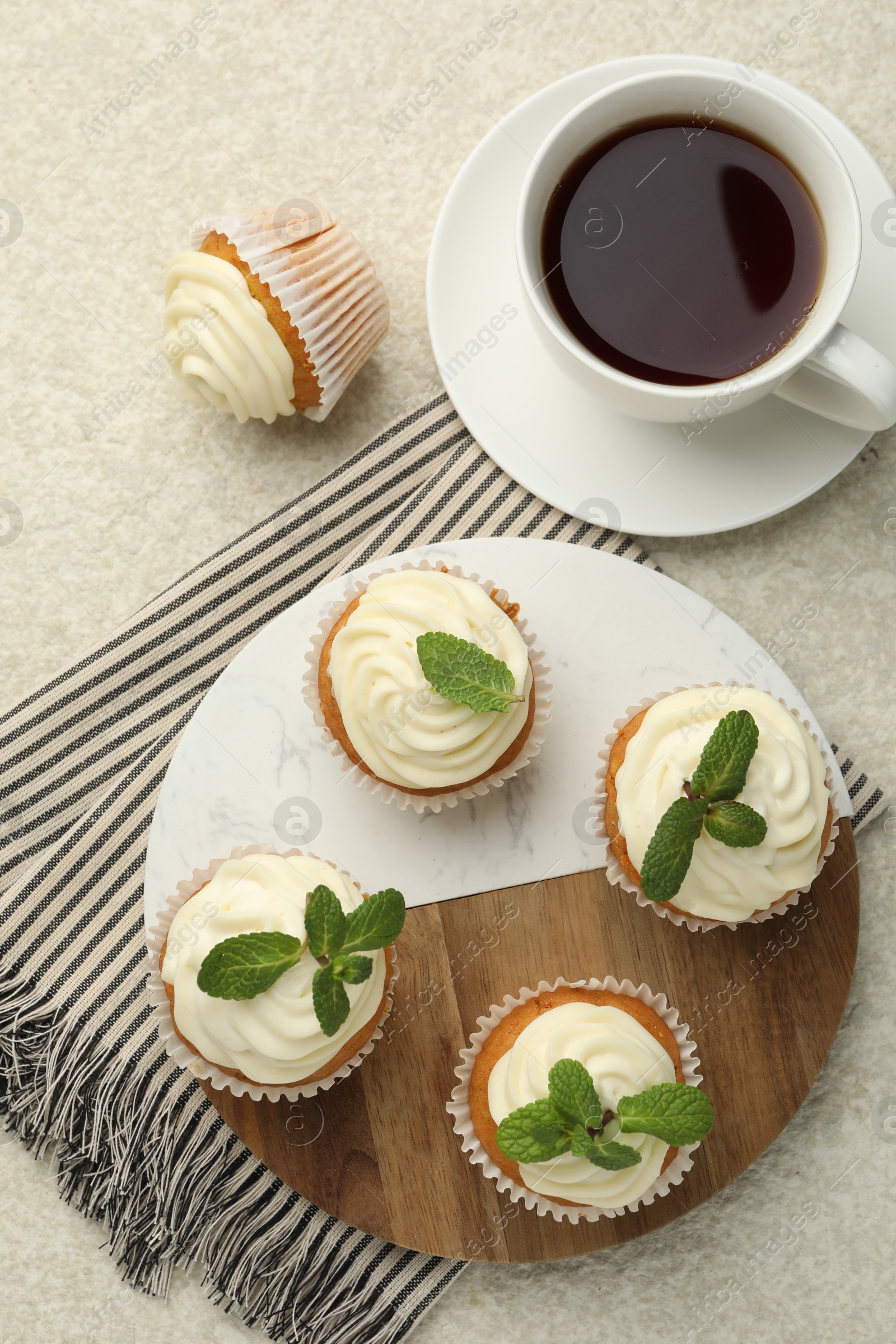 Photo of Delicious carrot cupcakes with mint and coffee on light textured table, flat lay