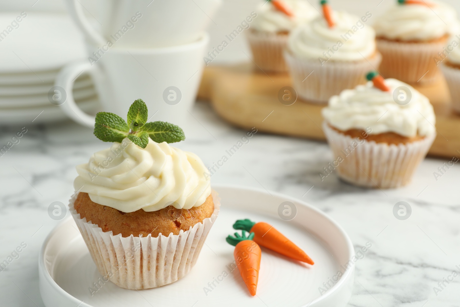 Photo of Delicious carrot cupcake with mint on white marble table, closeup