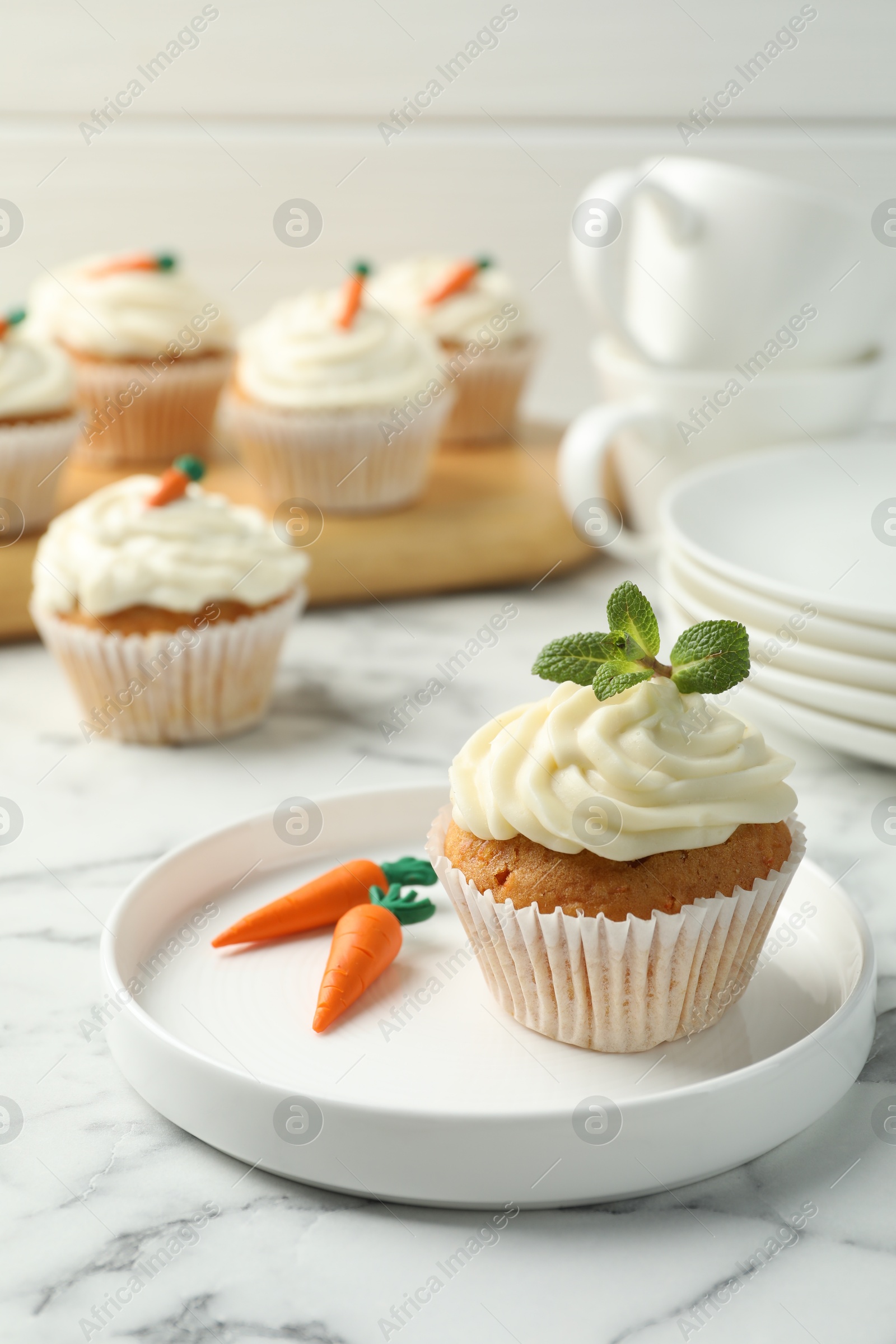 Photo of Delicious carrot cupcake with mint on white marble table