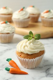 Photo of Delicious carrot cupcake with mint on white marble table, closeup