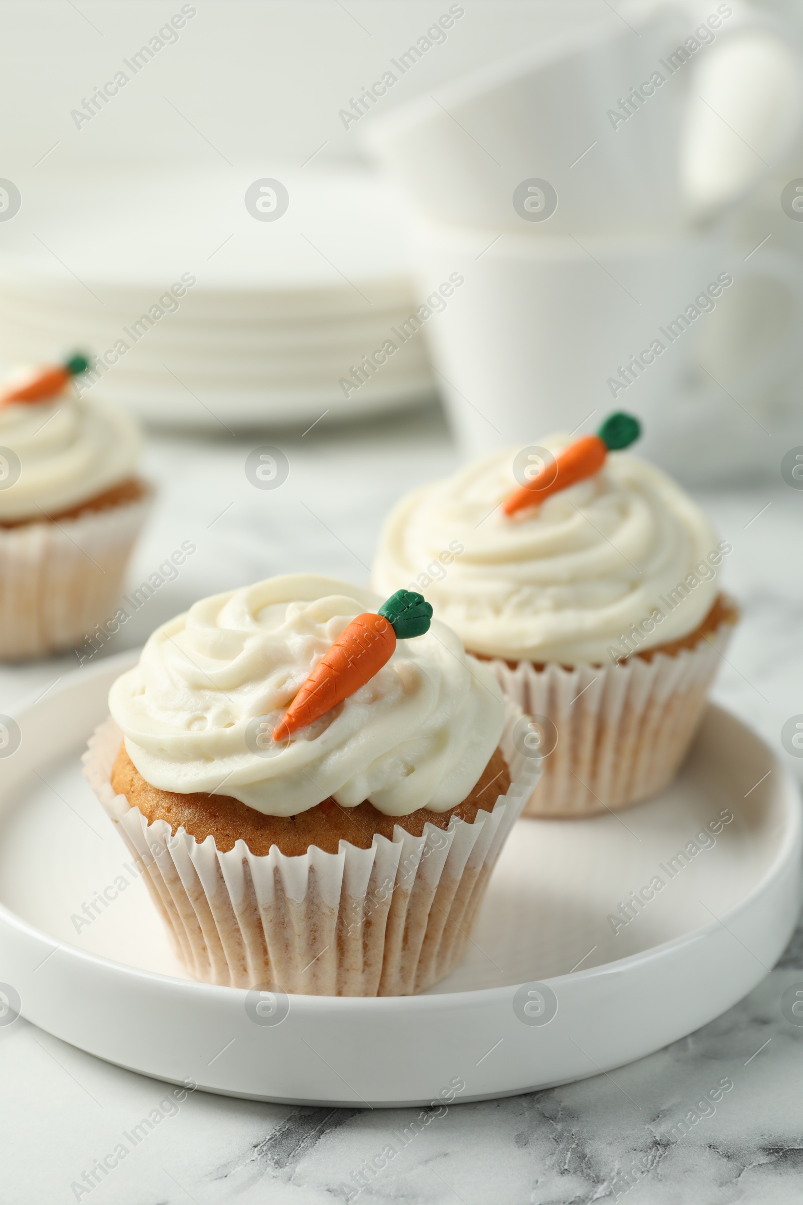 Photo of Delicious carrot cupcakes on white marble table, closeup