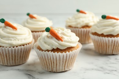 Photo of Delicious carrot cupcakes on white marble table, closeup