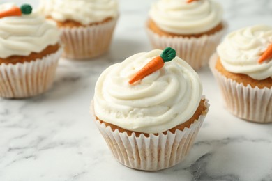 Photo of Delicious carrot cupcakes on white marble table, closeup