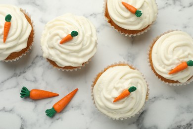 Photo of Delicious carrot cupcakes on white marble table, flat lay