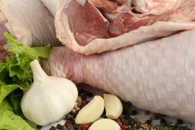 Photo of Raw turkey drumsticks and spices on table, closeup